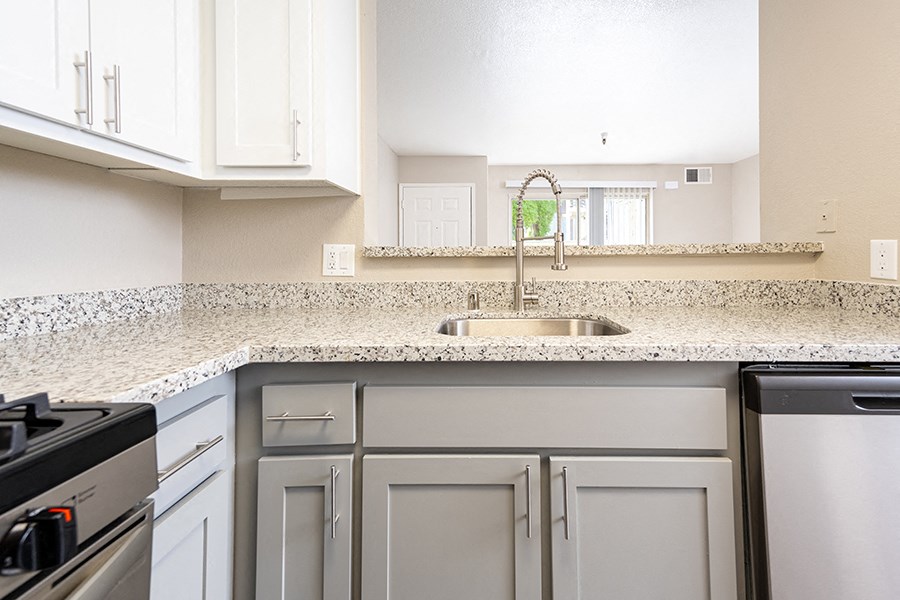 Apartments in San Leandro for Rent - Gateway Apartments - Kitchen Area with Sink, Granite-Style Counter, and Stainless-Steel Dishwasher