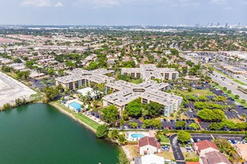 North Miami FL Apartments for Rent- Aerial View of Our North Horizons Community Featuring a Sparkling Pool and Lakeside View. - Photo Gallery 2