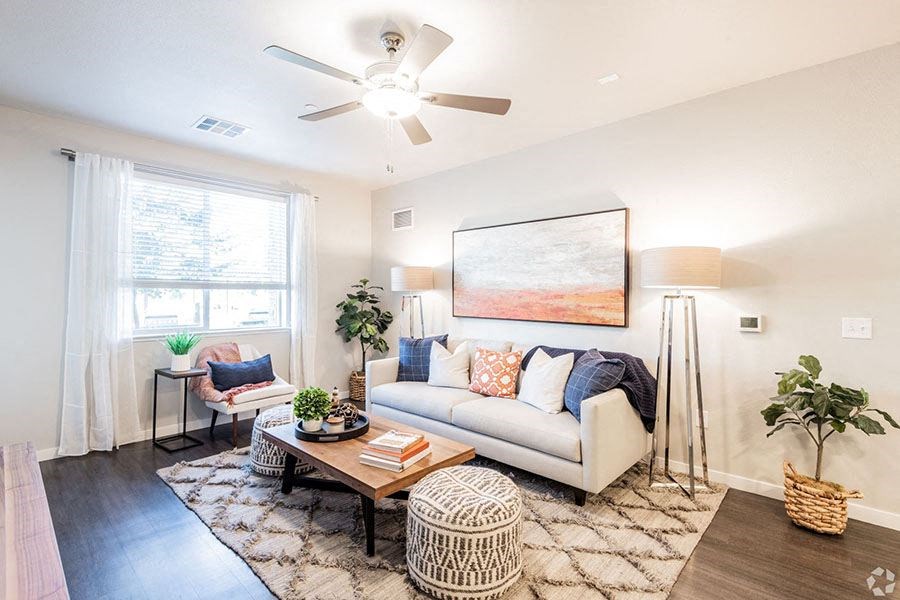 Roseville, CA Apartments for Rent- Harvest at Fiddyment Ranch-  Large Couch with Tan Area Rug and Wood-Style Floors