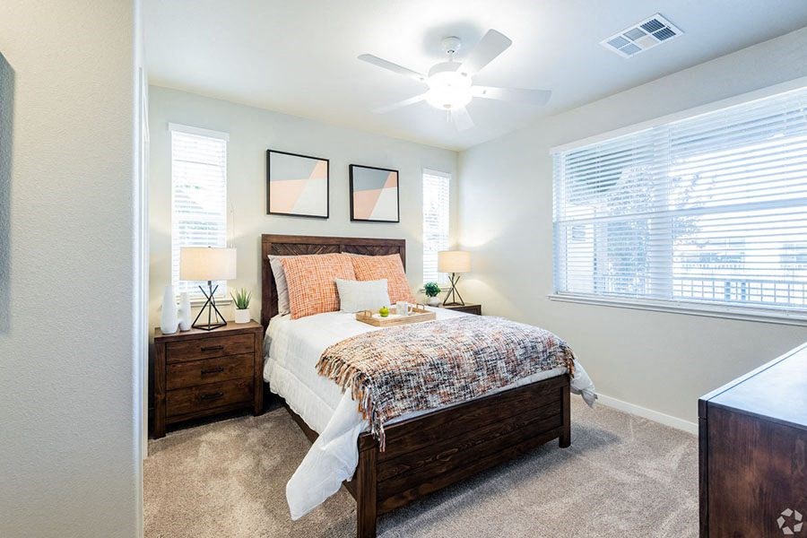 1 BR Apartments in Roseville CA - Harvest at Fiddyment Ranch - Bedroom with Plush Carpeting, Multiple Windows, and a Ceiling Fan