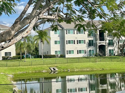 A large white building with a green lawn in front at Hawk's Landing Apartments, Florida
