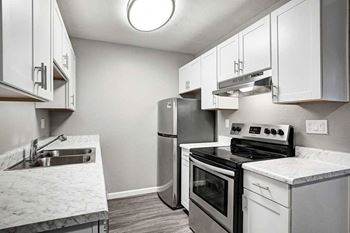 A kitchen with a stove, oven, and sink.