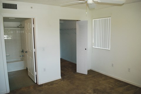 an empty bedroom with a closet and a bathroom