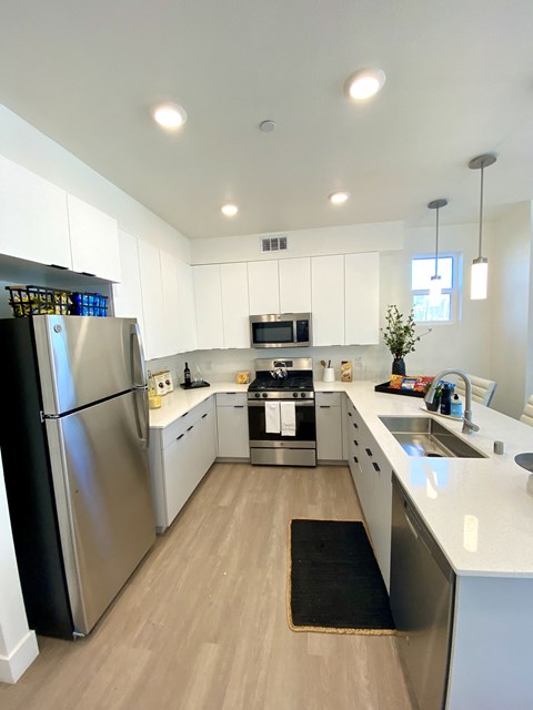 a large kitchen with stainless steel appliances and white cabinets