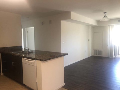 an empty kitchen and living room with a counter top