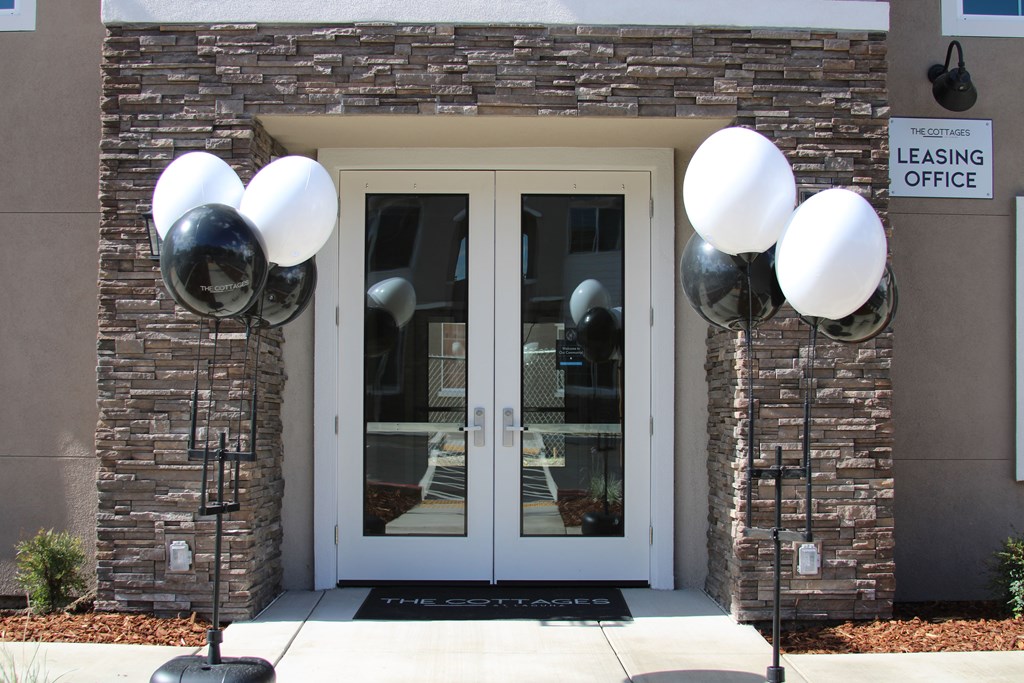 A leasing office is located in a building with a glass door and a sign above it.