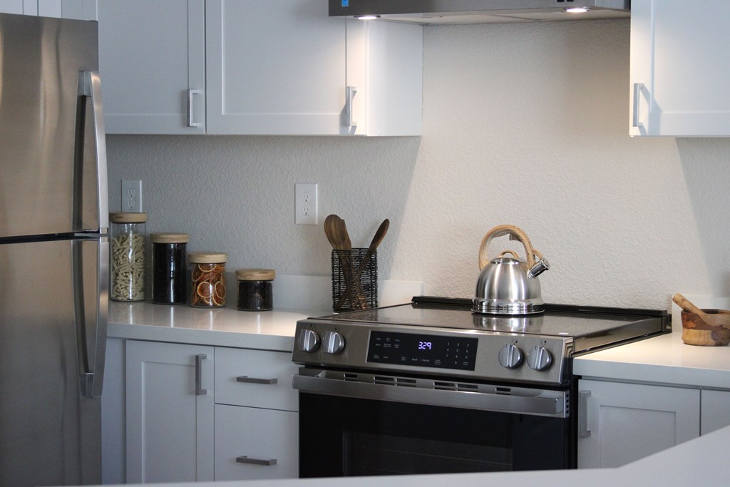 A modern kitchen with a stove top oven and a refrigerator.