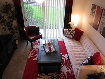 Monterey Pointe Apartments apartment home living area with balcony - Photo Gallery 6