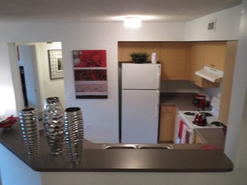 Monterey Pointe Apartments apartment home kitchen with white appliances and blonde colored cabinetry - Photo Gallery 5