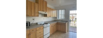 an empty kitchen with wooden cabinets and white appliances