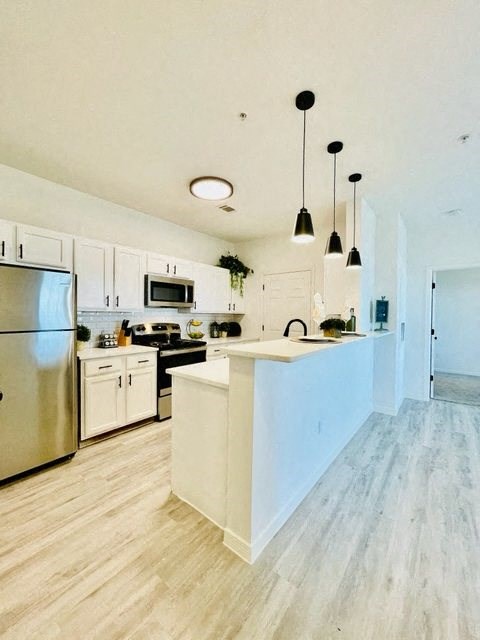 A kitchen with white cabinets and a white island.