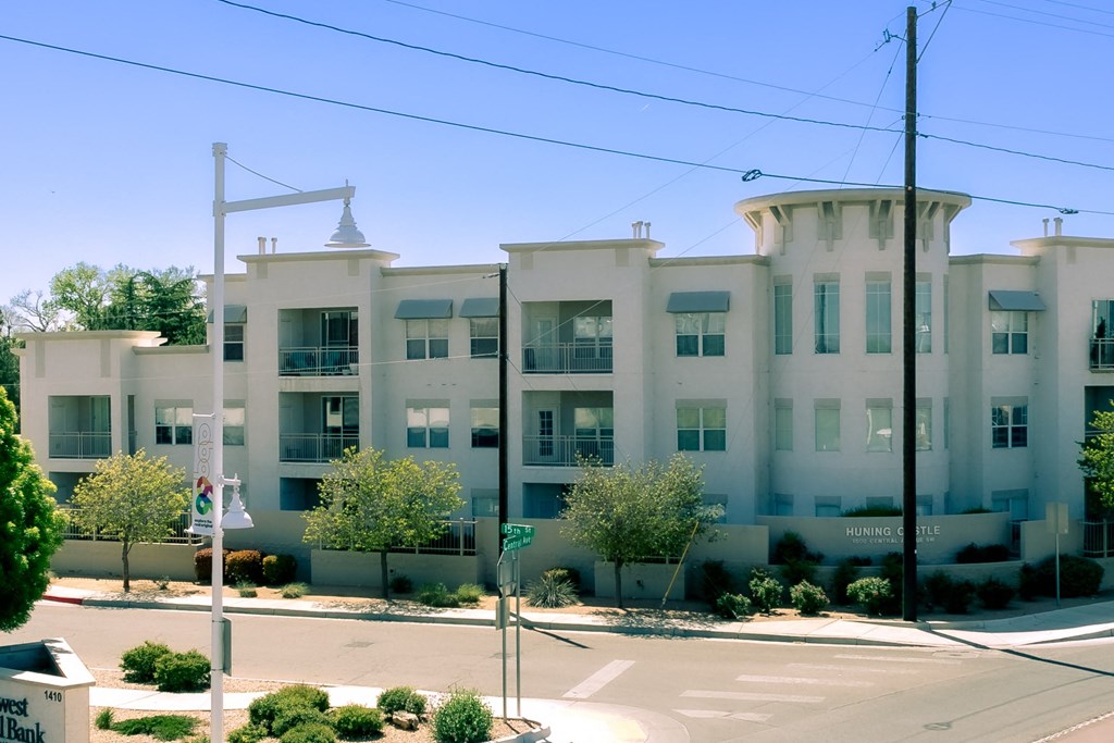 a large white apartment building with trees in front of it