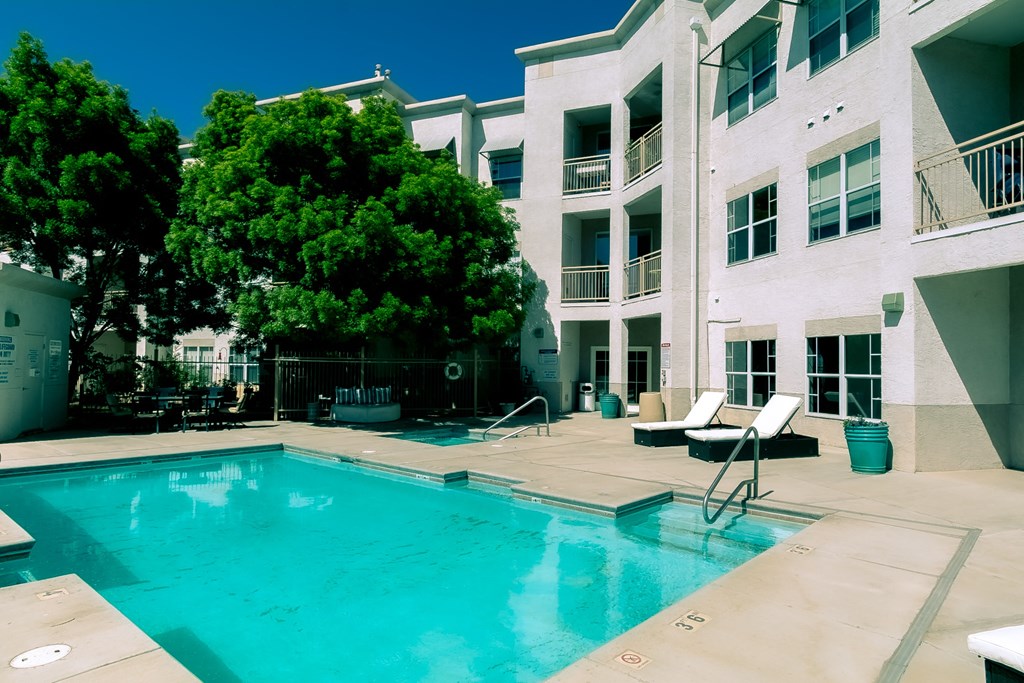 a large swimming pool in front of a white building