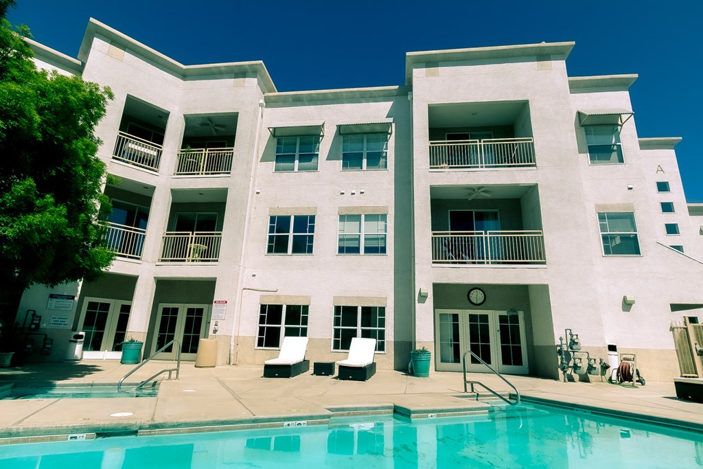 a large white building with a pool in front of it