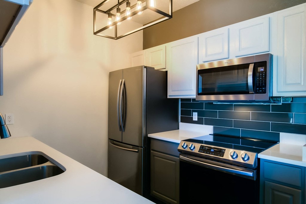 a kitchen with a stove top oven next to a refrigerator