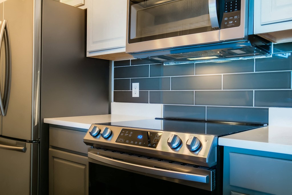 a kitchen with a stove top oven next to a refrigerator
