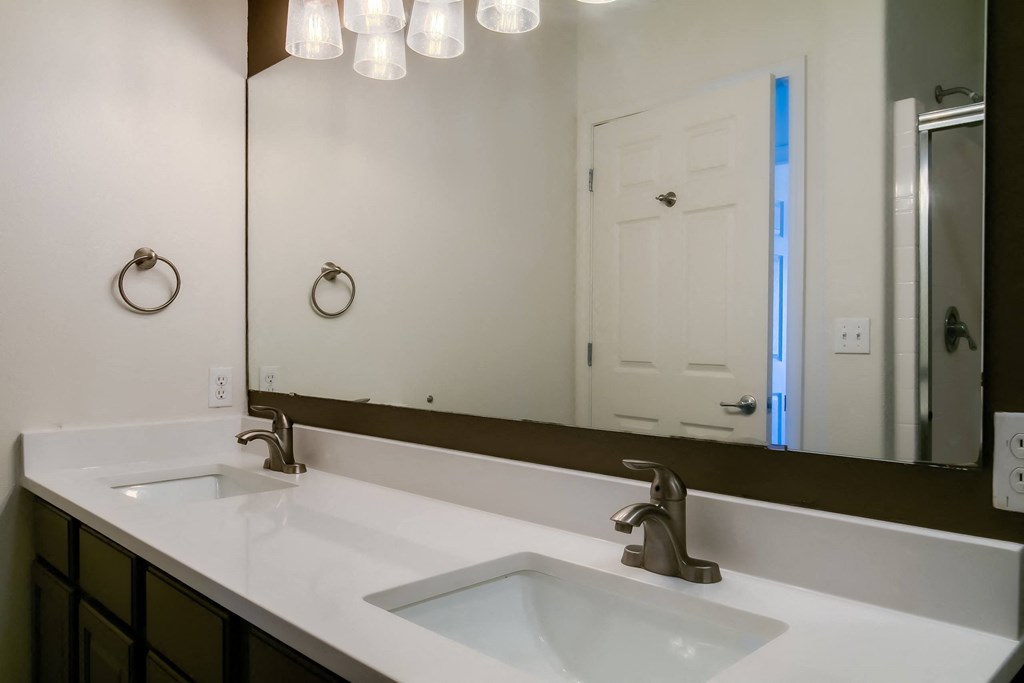 a bathroom with two sinks and a large mirror