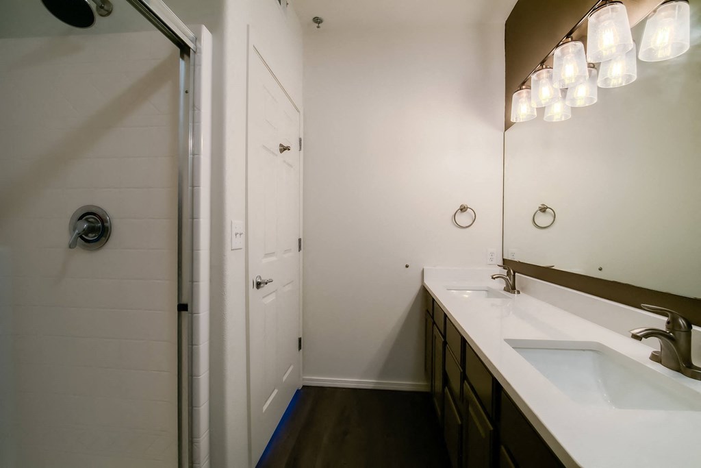 a bathroom with two sinks and a walk in shower