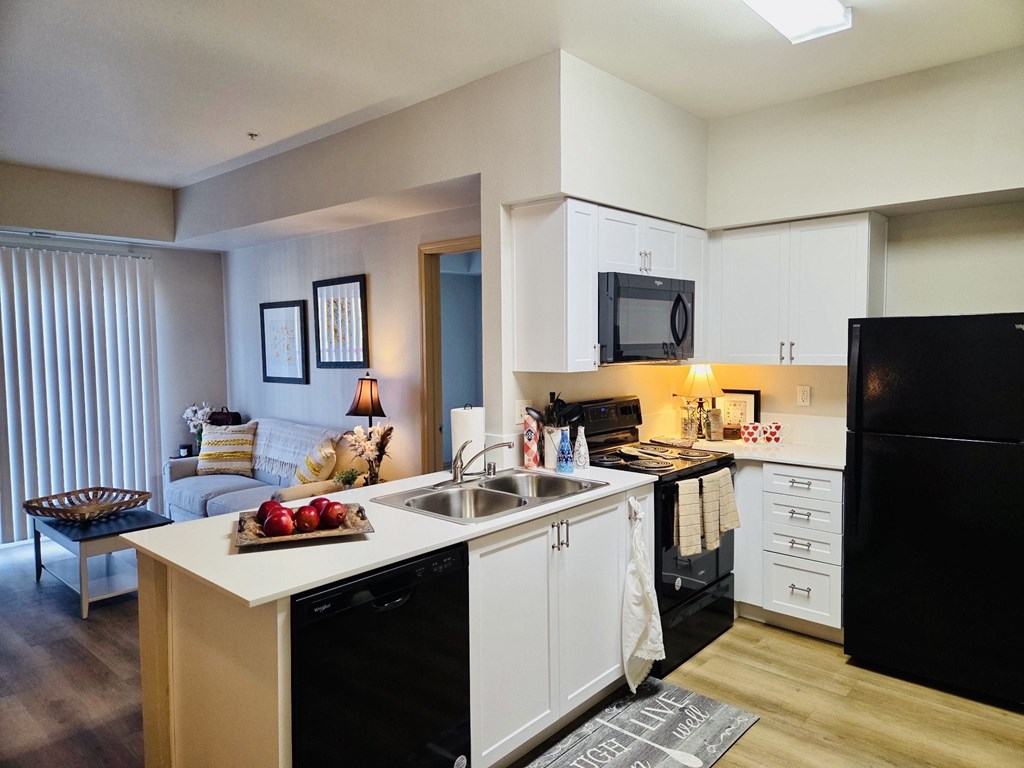 A kitchen with black appliances and white cabinets at Everett Senior Community, Everett
