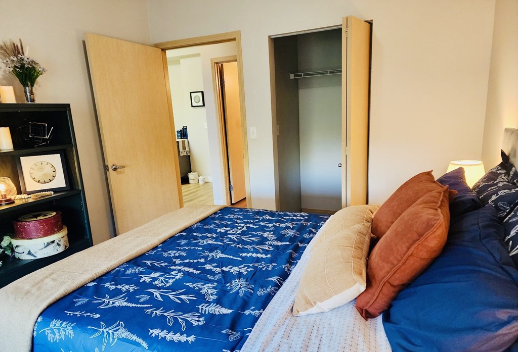 A bedroom with a blue bedspread and a wooden door at Everett Senior Community, Everett, 98201