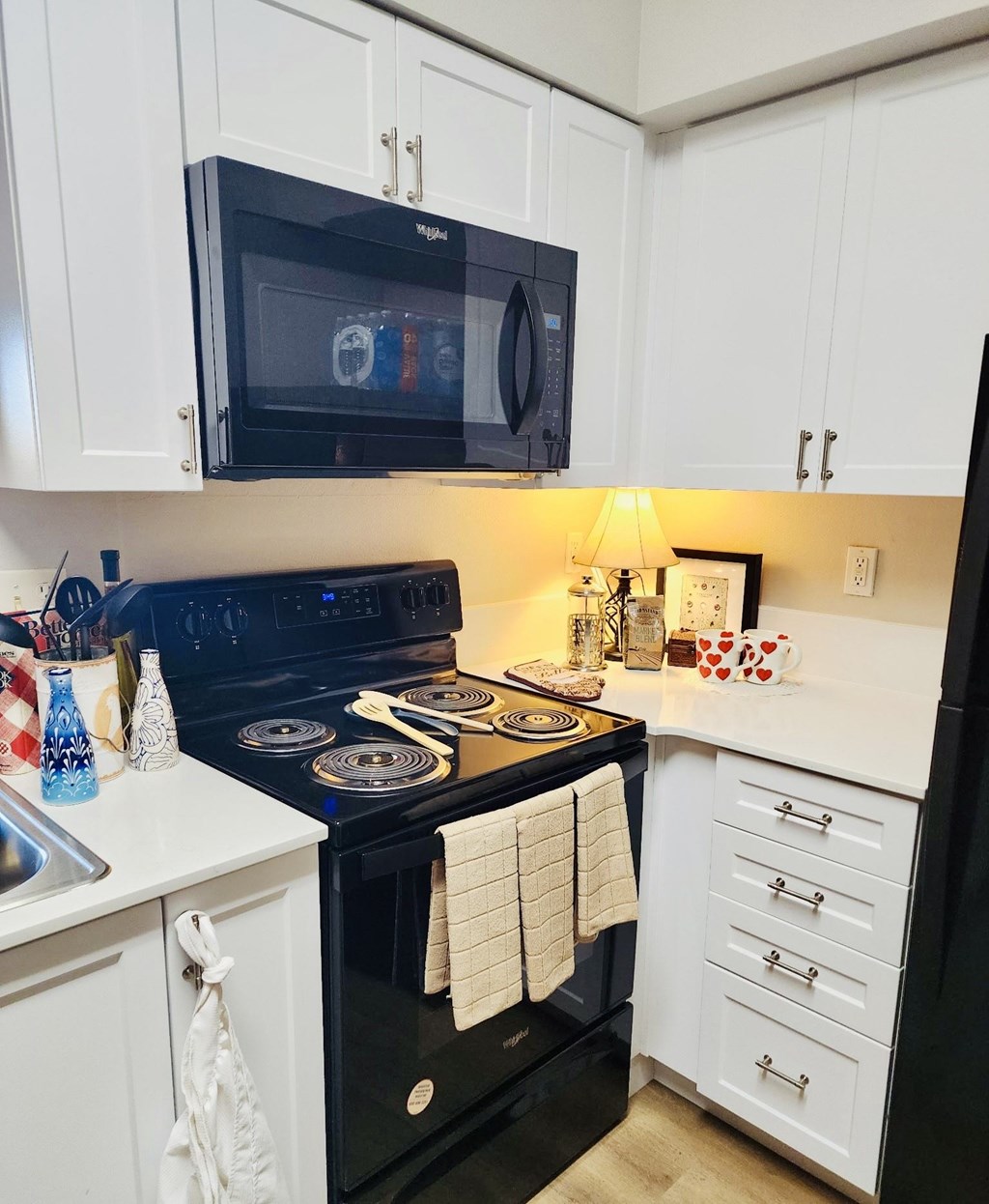A black stove top oven with white towels hanging on it at Everett Senior Community, WA, 98201