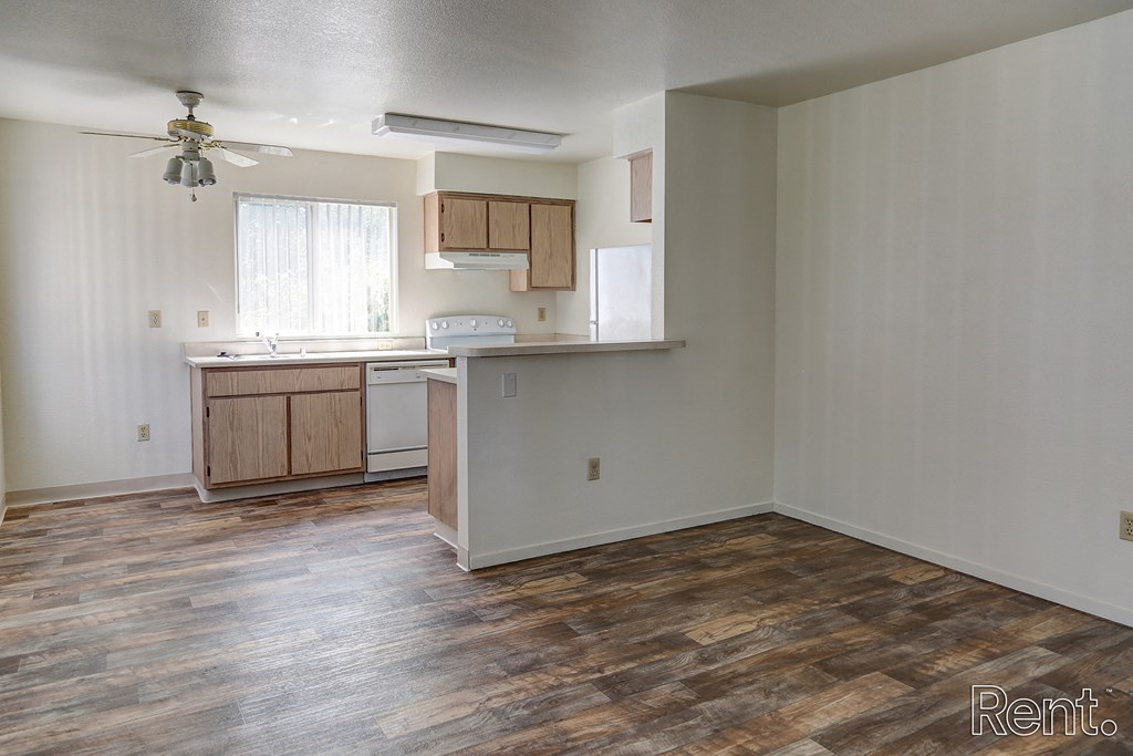 an empty kitchen and living room with a ceiling fan