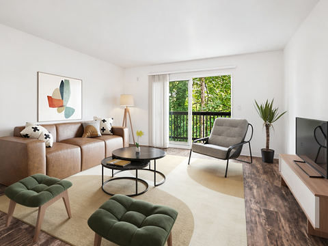 A living room with a brown couch, a green ottoman, a coffee table, and a television.