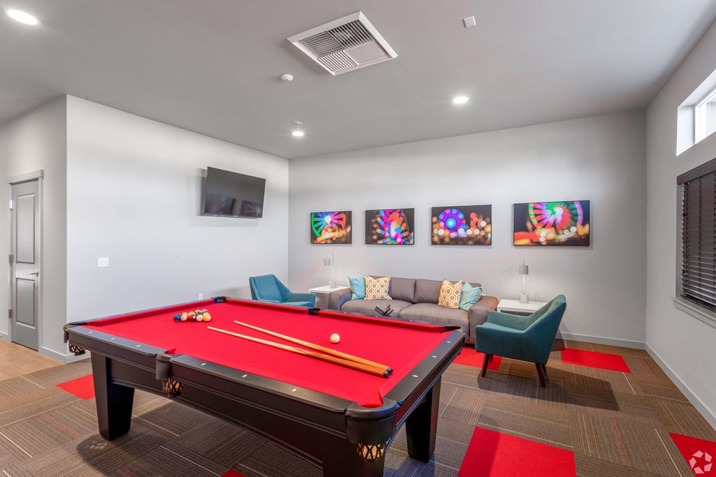 a games room with a red pool table and a couch