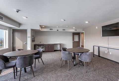 a conference room with tables and chairs and a kitchen