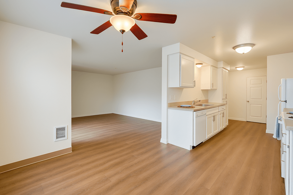 A room with a ceiling fan and wooden flooring at THE VILLAGE Apartments, Oregon
