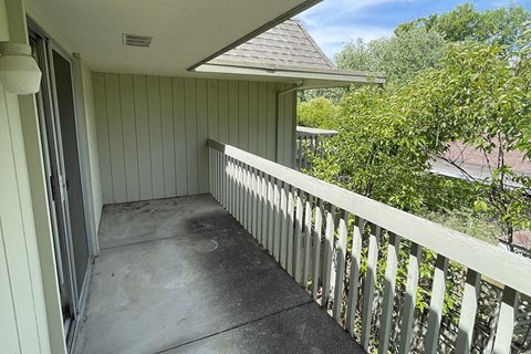 a porch with a white fence and a house in the background at OTAVON APARTMENTS, Novato