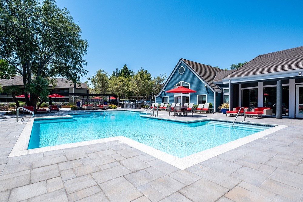 Pittsburg Apartments - Kirker Creek - Pool with Lounge Chairs, Patio Furniture, and Umbrellas.
