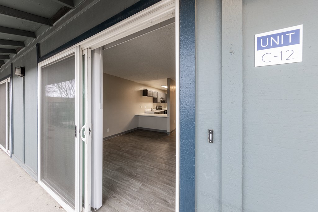a door leading into a room with a kitchen in the background