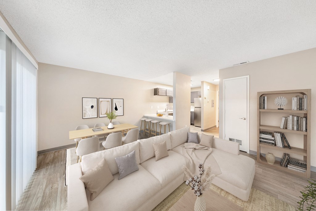 a living room with a large couch and a dining room in the background