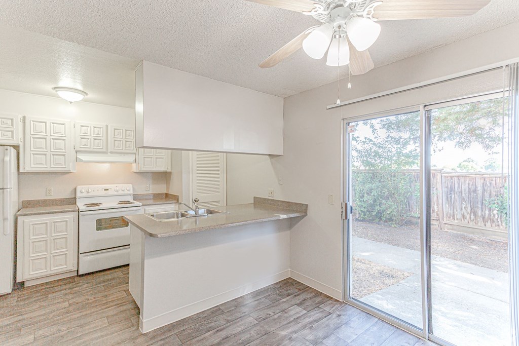 an empty kitchen with a sliding glass door to the patio