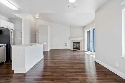 A kitchen with white cabinets and a wooden floor.