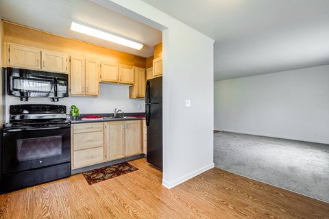 A kitchen with black appliances and wooden cabinets.at Lake Washington Apartments, Washington