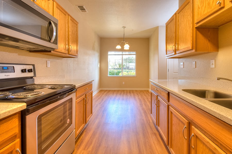 A kitchen with wooden cabinets and a stove top oven.