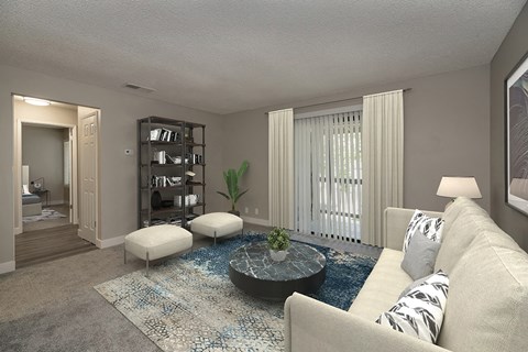 A living room with a beige sofa, a round coffee table, and a rug with a blue pattern.