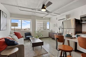 A modern living room with a grey couch, a red throw pillow, and a wooden coffee table at LOFT 205 Apartments, Nevada