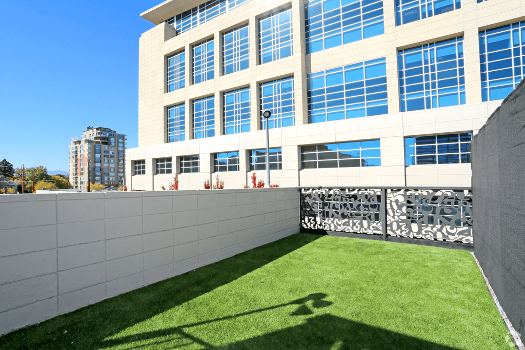 A modern building with a grassy area in front at LOFT 205 Apartments, Nevada, 89501