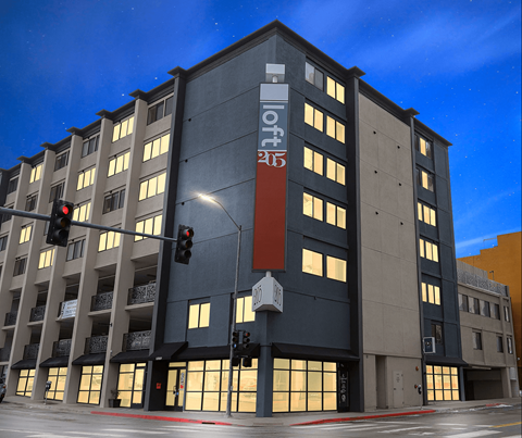 A modern building with a dark grey facade and a red sign on the front at LOFT 205 Apartments, Reno, NV
