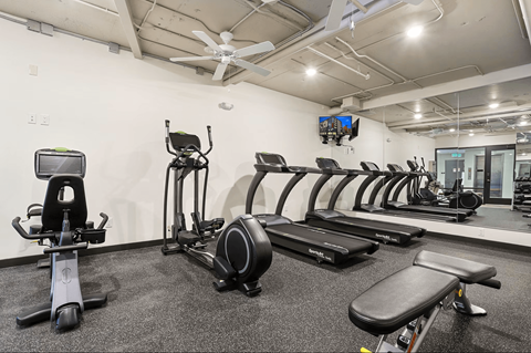 A gym with a variety of equipment including a stationary bike, rowing machine, and treadmills. at LOFT 205 Apartments, Reno, NV, 89501