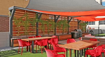 A patio with red chairs and tables under a grey canopy at LOFT 205 Apartments, Reno, Nevada