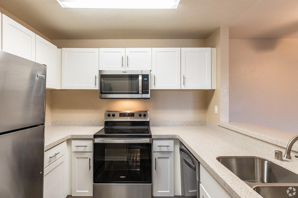 a kitchen with stainless steel appliances and white cabinets at THE MEADOWS, Santa Rosa