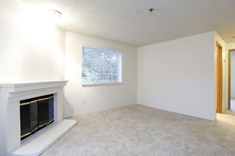 Des Moines Apartments for Rent - Marina Club - Living Room with Fireplace, Carpeting, and a Large Window