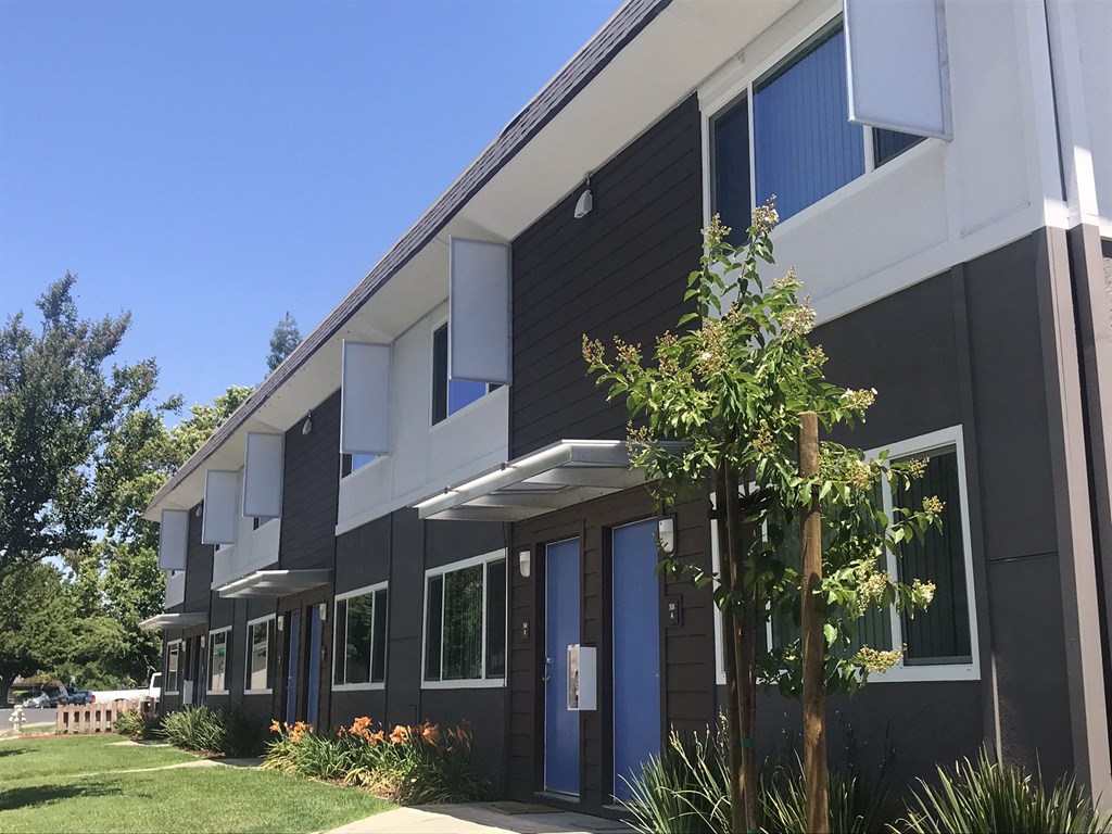 a picture of a building with black and white siding and a blue door at MEADOWS HOLLY, VACAVILLE California