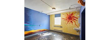 a mural of a sun on the wall of a room at MILEPOST 5 Apartments, PORTLAND, 97213