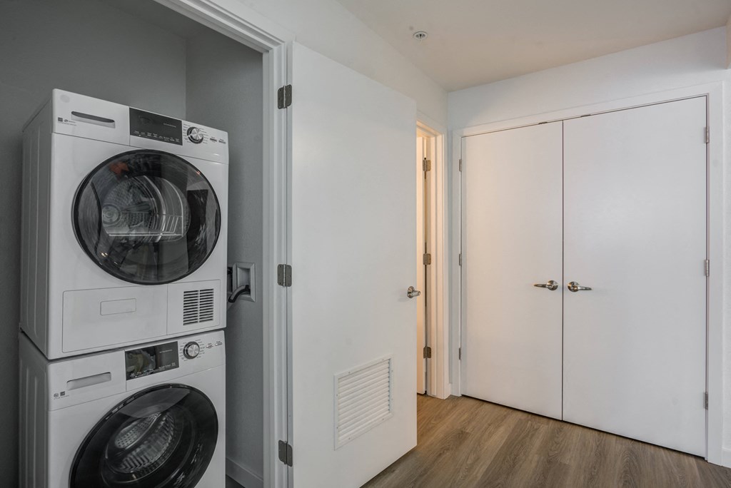 a washer and dryer in a room with a door to a closet