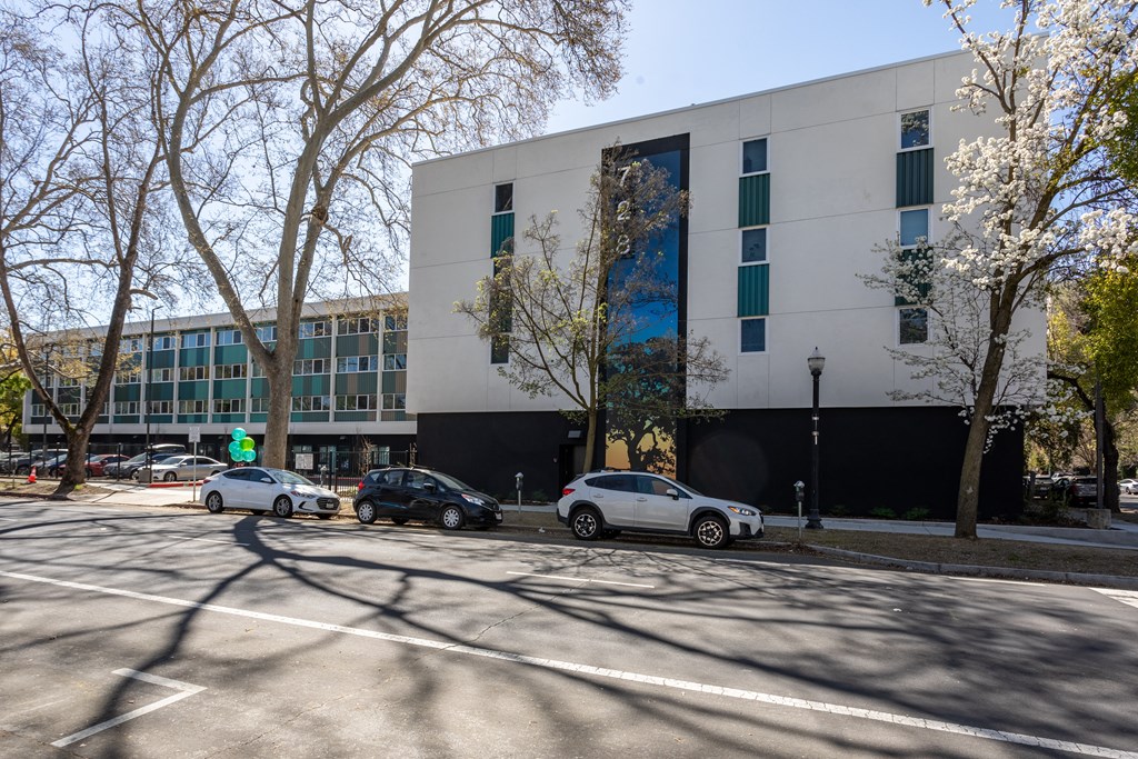 the exterior of a building with cars parked in front of it